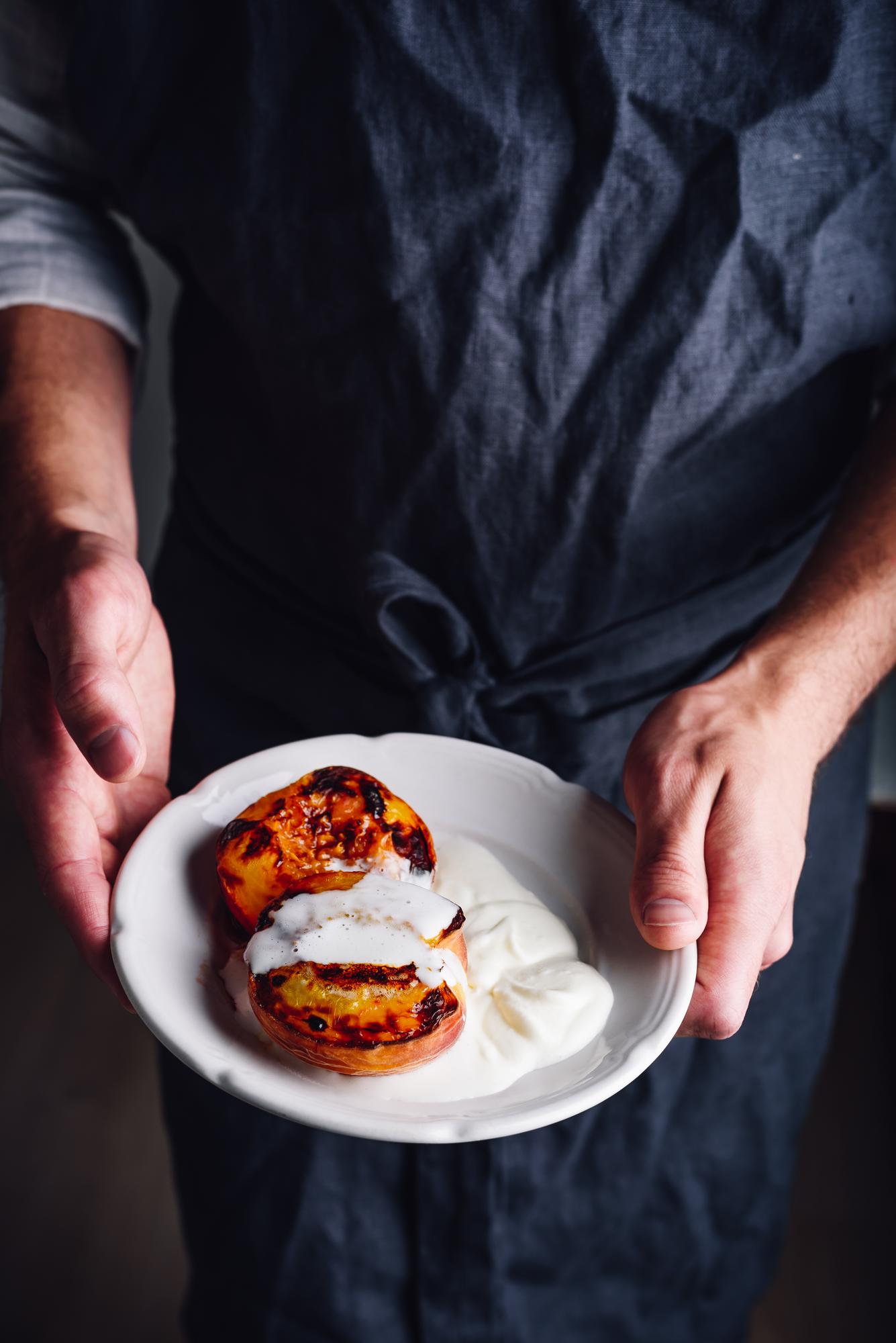Instructor demonstrating a plated dish in a warm kitchen